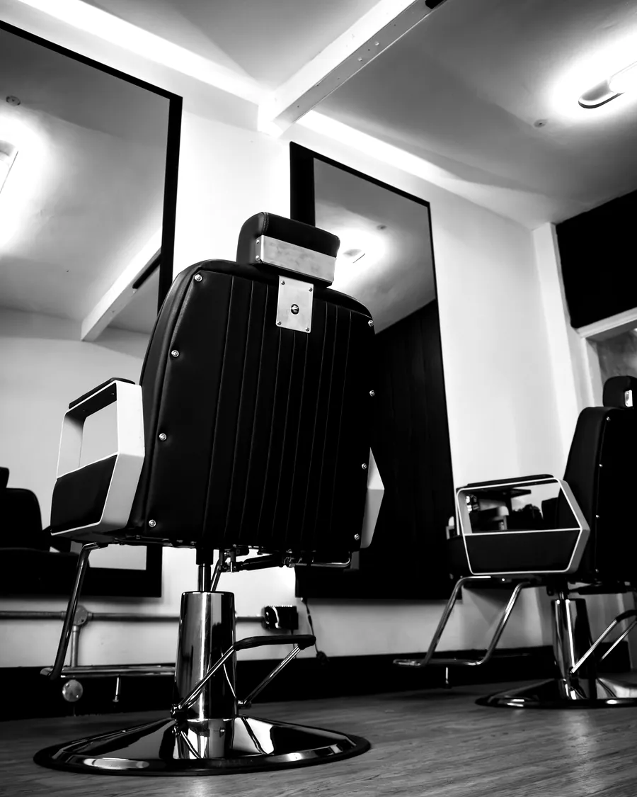 An empty black barber's chair on the shop floor