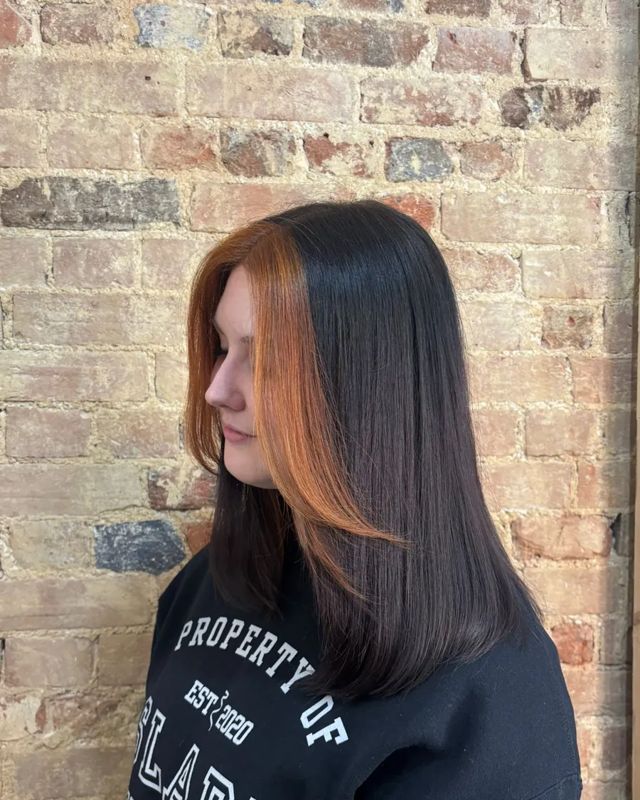 Sleek dark hair with a bright copper panel at the front
